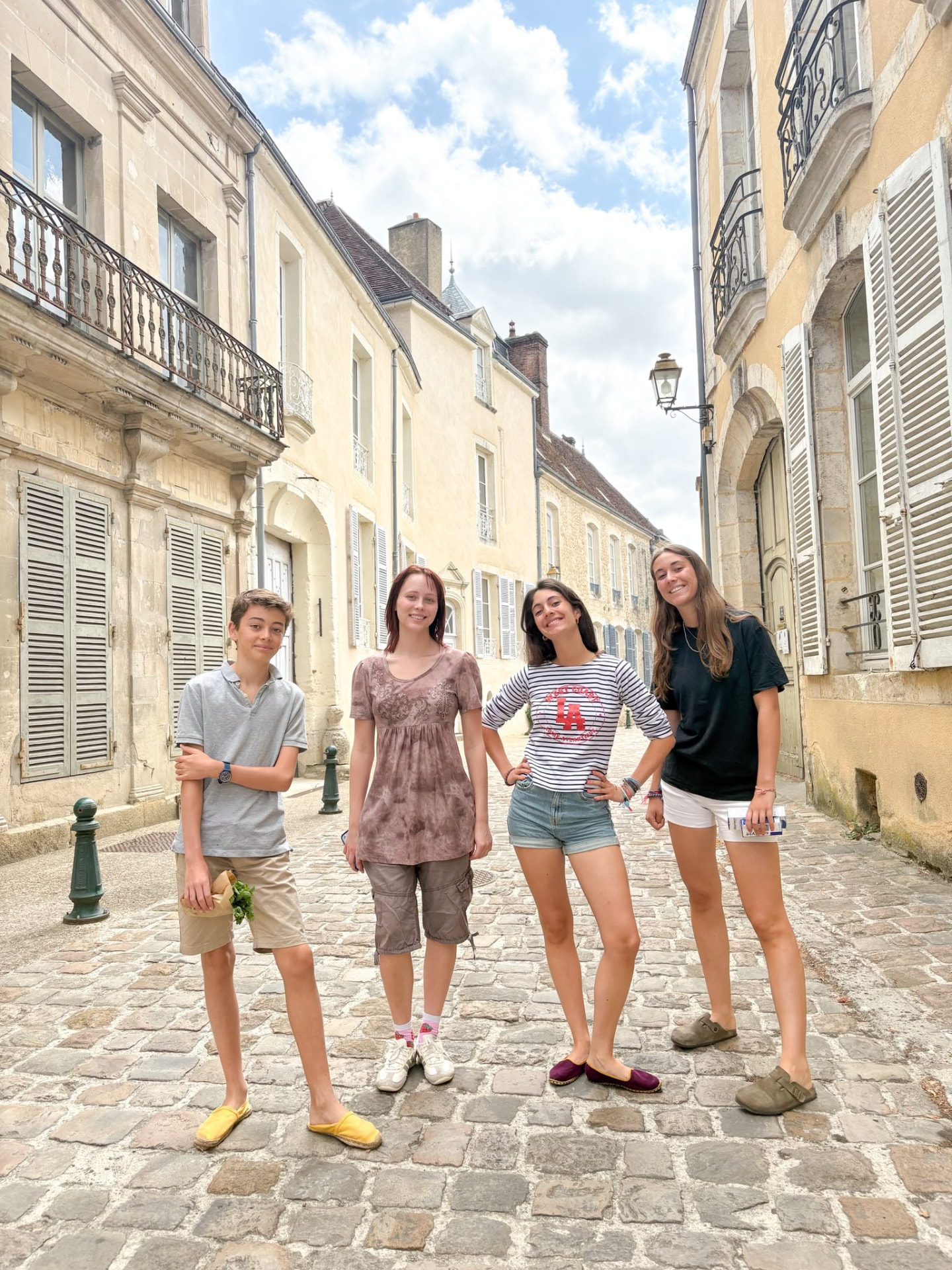 Four young people on a cobbled French village street during an exchange visit
