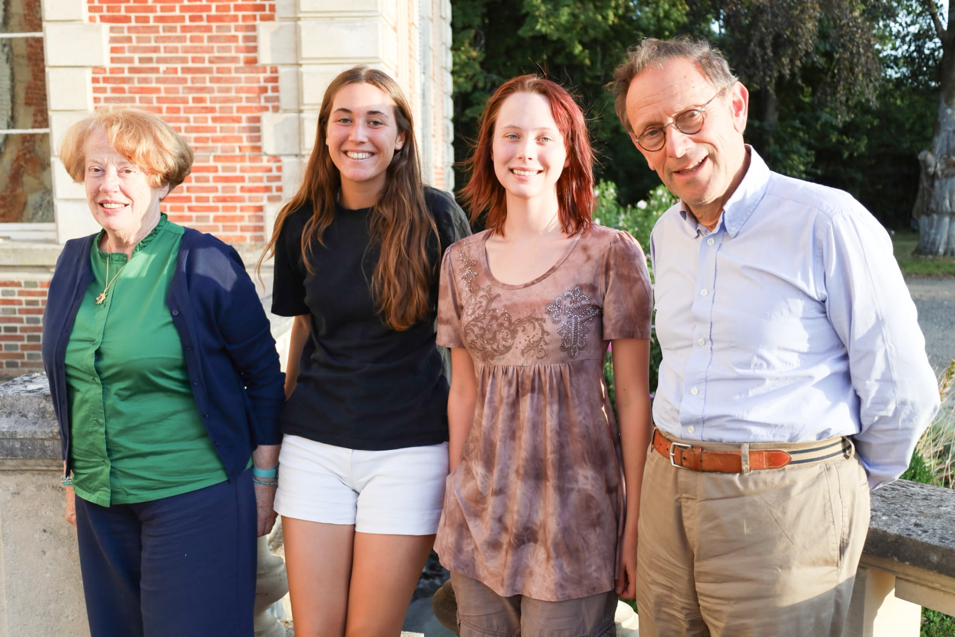 A host family with two exchange participants outside their home in France